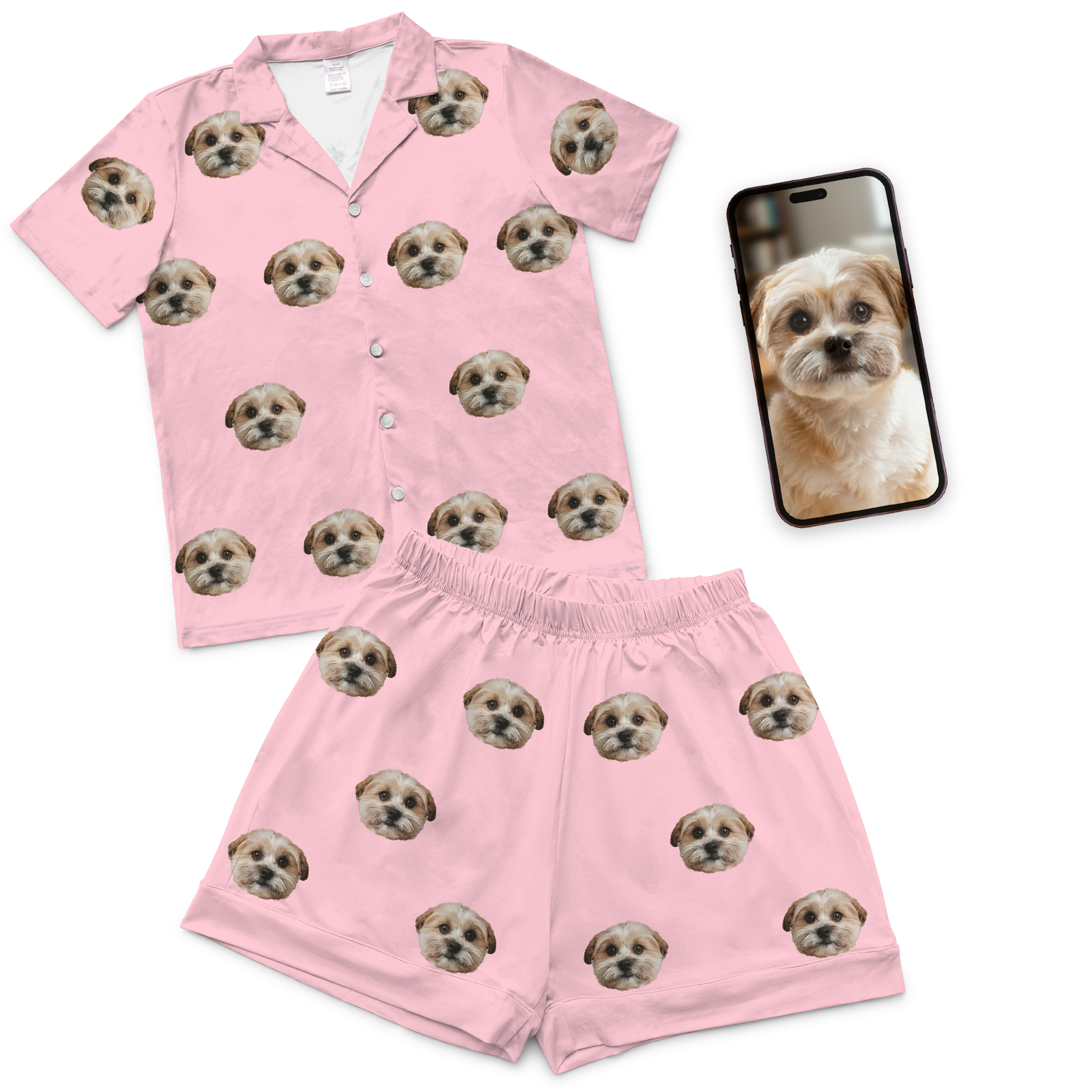 Pink pajama set with dog face pattern next to a phone with a dog photo
