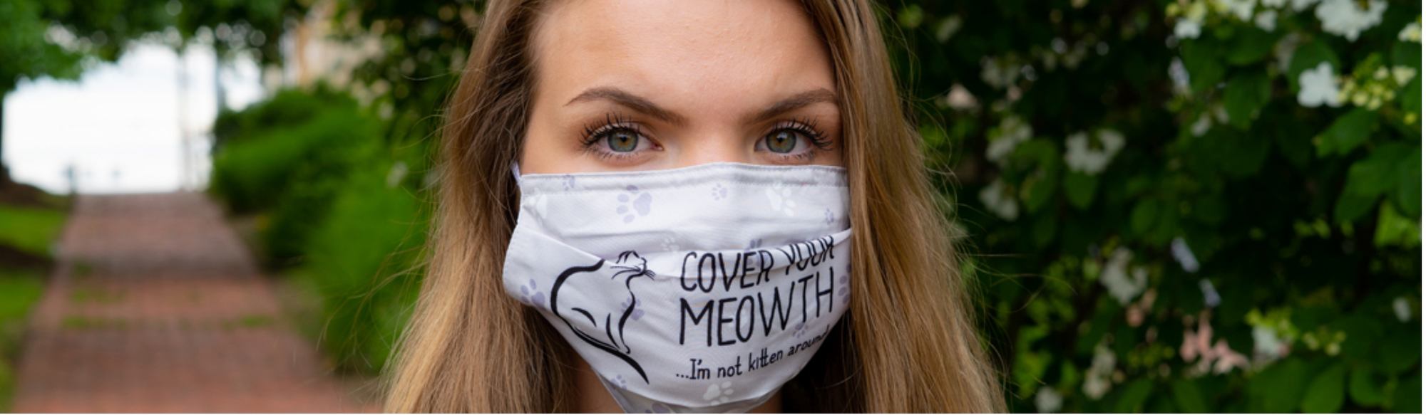 Woman wearing the Cuddle Clones "Cover Your Meowth" cat face mask.