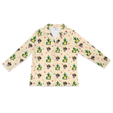 A long-sleeve button-up shirt with a cream-colored base and an all-over festive print featuring Santa Claus, cacti, candy canes, and snowflakes.