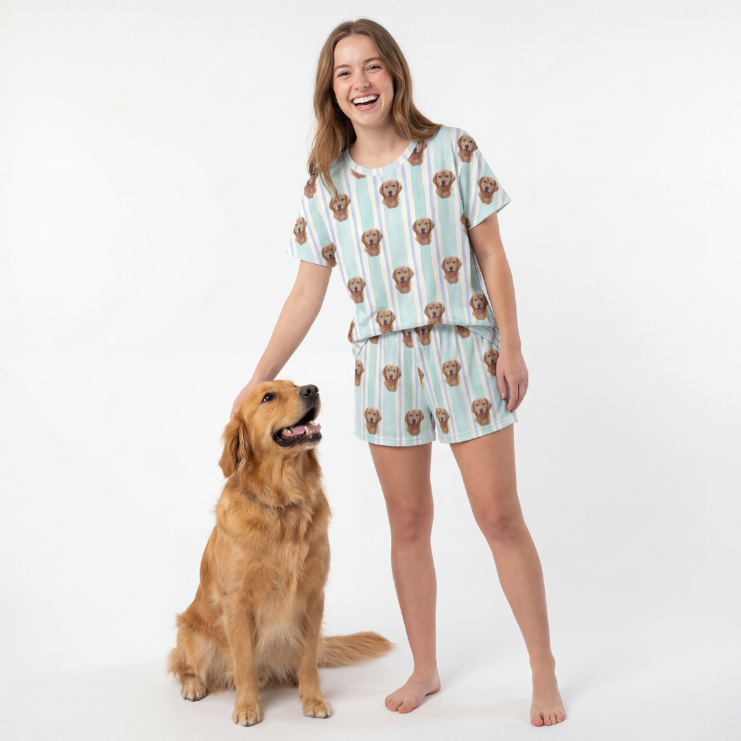 Woman wearing a dog-themed pajama set standing next to a dog on a white background[MintStripes]