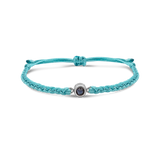 Turquoise braided bracelets with a black bead charm.