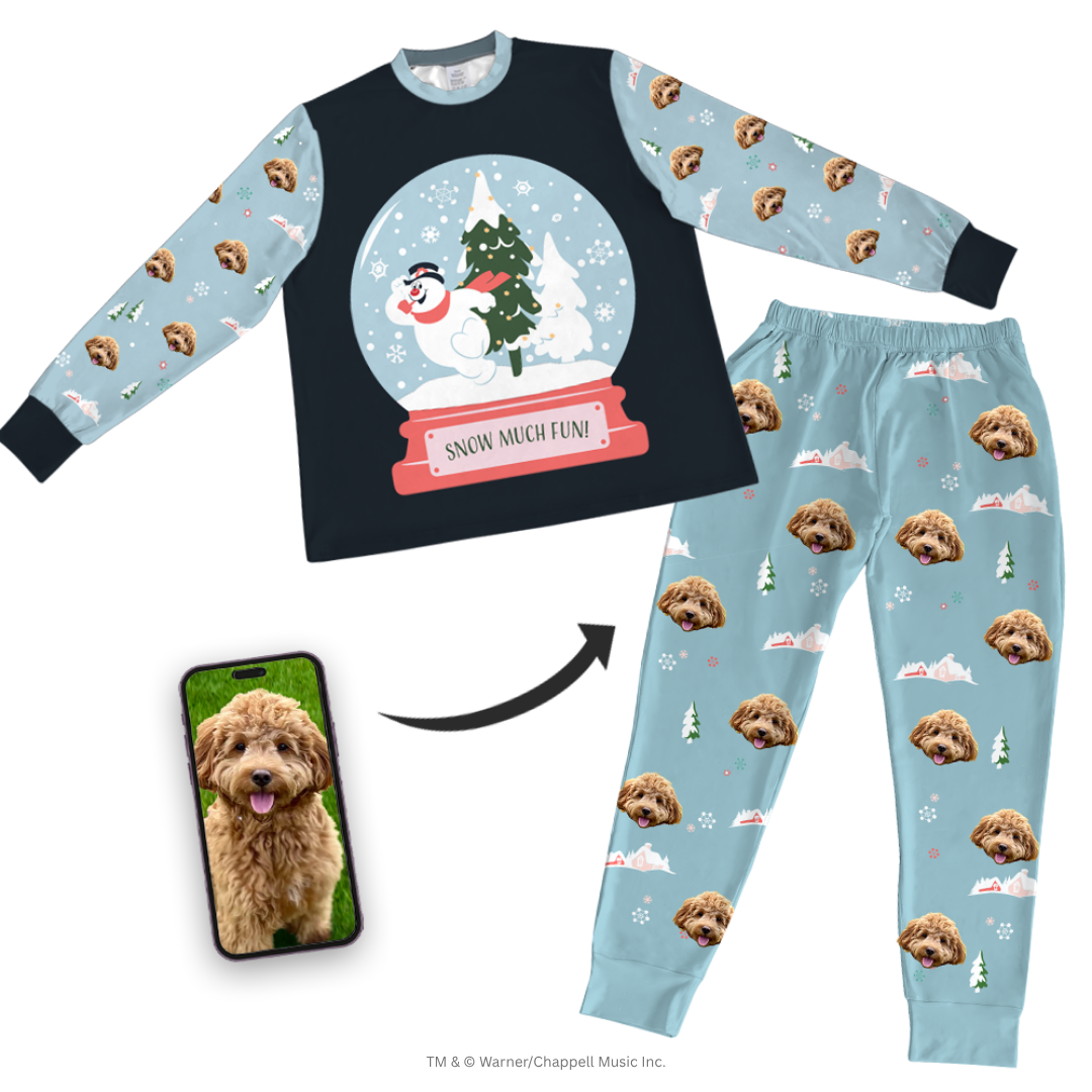 Children's pajama set with snow globe graphic on a dark top and dog pattern on light blue pants, featuring a phone with a dog photo