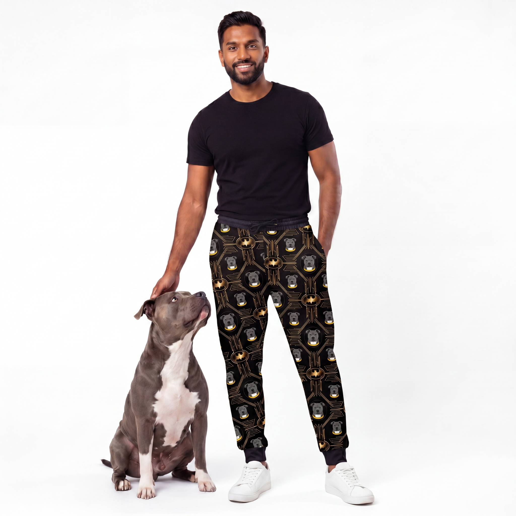 Man wearing Iconic Batman sweatpants with a dog on a white background