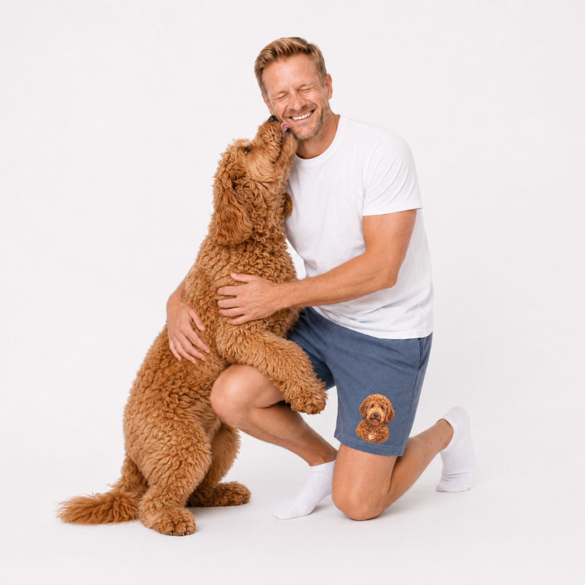 Man in white t-shirt and navy shorts with a brown dog on a white background