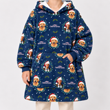 A person wearing a navy blue hooded sweatshirt with an all-over Christmas-themed print featuring golden retriever faces, Santa hats, holly leaves, snowflakes, and the text 'Merry Christmas Vacation.' The photo is cropped from the neck down against a plain light gray studio background.