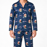 A man wearing a navy blue long-sleeve pajama set with a Christmas-themed print featuring a dog in a Santa hat, the text 'CHRISTMAS VACATION', and holiday graphics, shown against a plain white background.