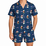 A man wearing a matching navy blue pajama set with a festive Christmas print featuring dog portraits, Santa hats, holly, and the text 'CHRISTMAS WALKER'.