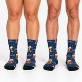 Three pairs of custom crew socks with a navy blue Christmas pattern featuring a custom photo of a dog wearing a Santa hat, shown on a model's legs against a white background.