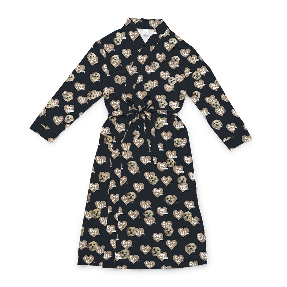 A black full-length robe with a tie belt, featuring a repeating custom pattern. The pattern includes several close-up photos of a small, light-colored dog's face, interspersed with graphics of tan hearts that contain the white text "Dog Mom".