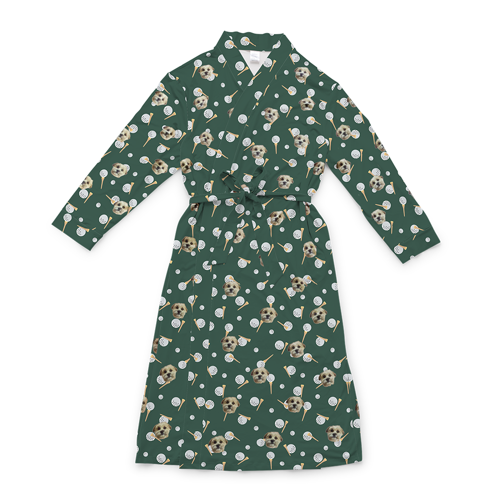 A dark green full-length robe with a tie belt, featuring a repeating custom pattern. The pattern includes several close-up photos of a small, light-colored dog's face, interspersed with graphics of white dimpled golf balls and wooden tees. 