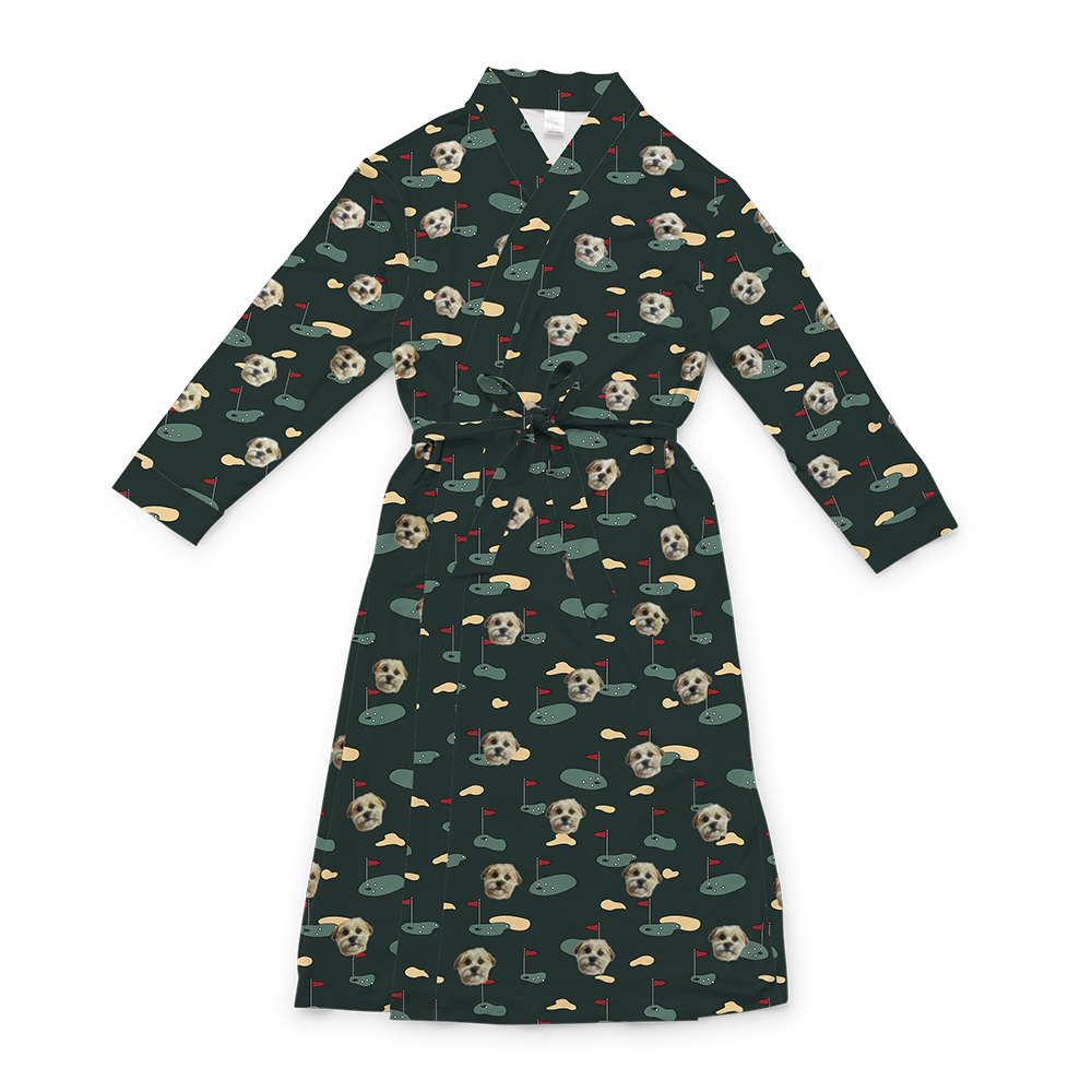 A dark green full-length robe with a tie belt, featuring a repeating custom pattern. The pattern includes several close-up photos of a small, light-colored dog's face, interspersed with graphics of green golf greens with red flags, and tan sand traps. 