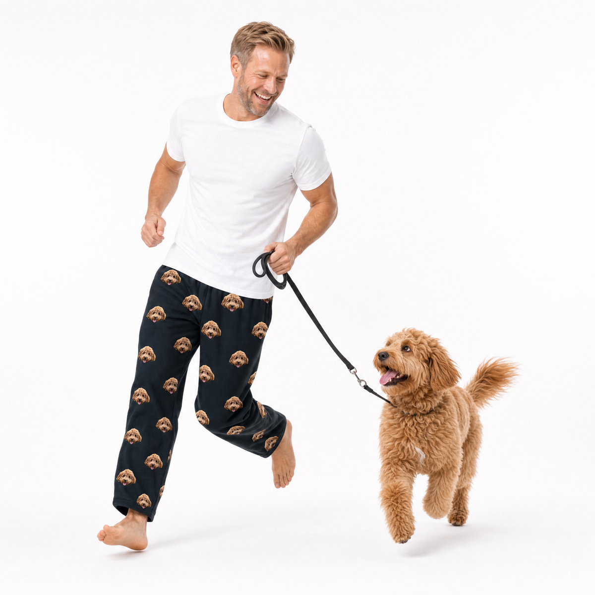 Man walking a dog wearing black pants with brown dog face pattern on a white background
