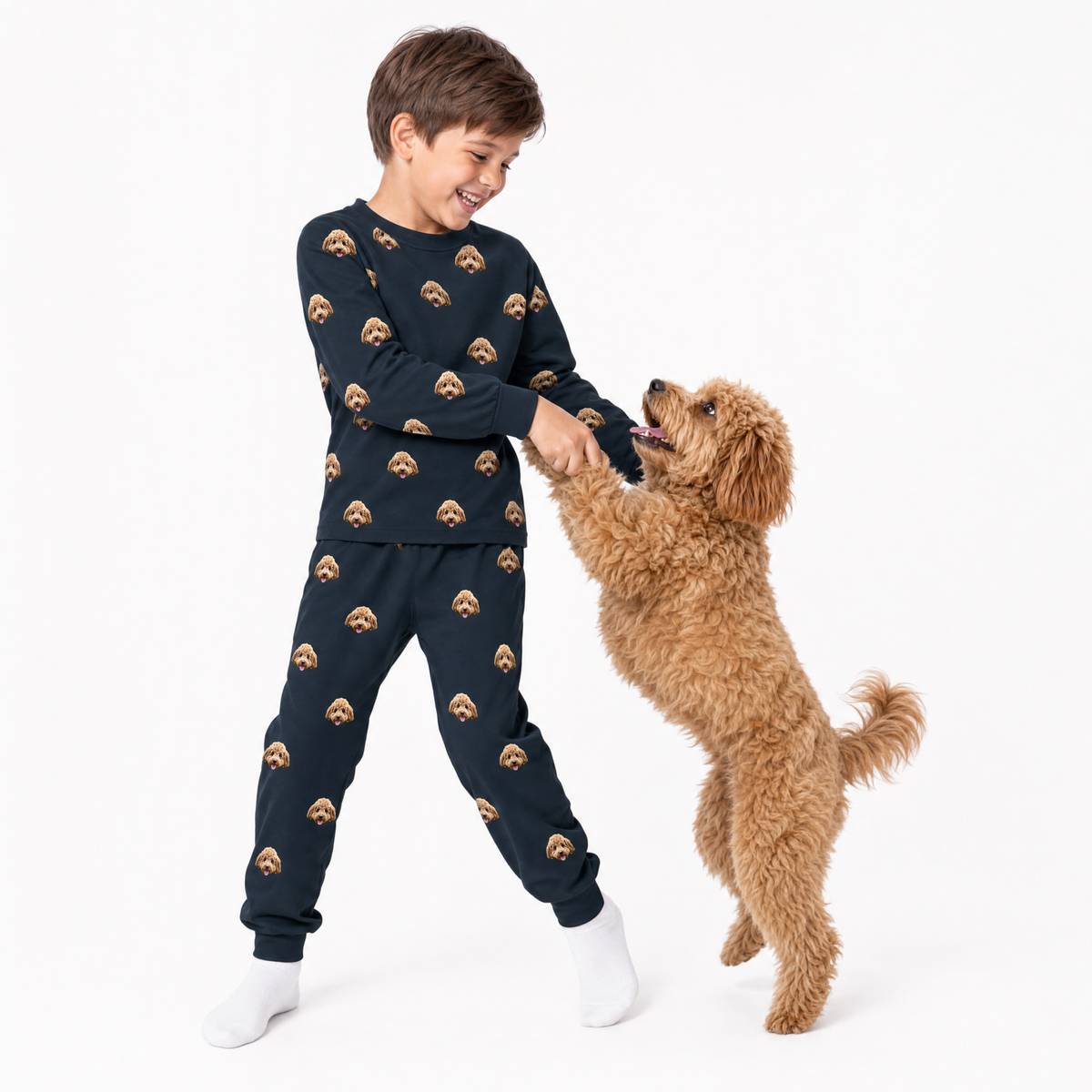Child wearing a black jogger pajama set with dog pattern, shaking hands with a brown dog on a white background