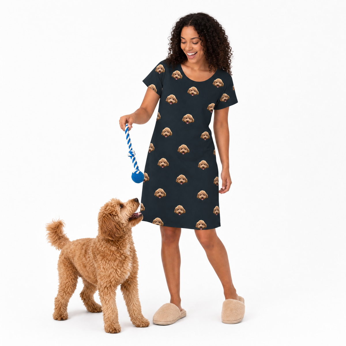 Woman in a black dress with dog pattern interacting with a dog on a white background