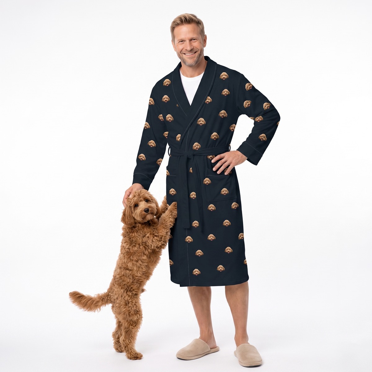 Smiling man in black dog-print robe petting a golden doodle standing on hind legs, white background