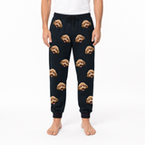 Person wearing black sweatpants with dog face pattern on a white background