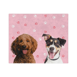 Pink blanket with paws featuring the portraits of two dogs 