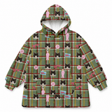 A hooded sweatshirt with a green plaid pattern and an all-over print of black-and-white cats, pink figures, and small pink circular badges, shown on a plain white background.