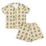 A two-piece children's pajama set featuring a short-sleeve button-up shirt and matching shorts in a warm cream color, both printed with a repeating pattern of green cacti, black-and-white panda faces, and small red candy canes.