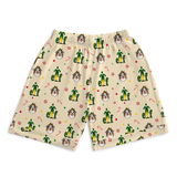 A pair of beige shorts with an all-over Christmas elf and dog print, featuring green elves, brown dogs, candy canes, and paw prints on a light beige background.
