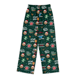 A pair of dark green Christmas pajama pants featuring a repeating pattern of white Dalmatian dogs in Santa hats, Christmas trees, gifts, and festive text including 'DAD, the gift is on the table' and 'DAD, the Vlog, the gift is Christmas'.