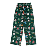 A pair of dark green Christmas pajama pants featuring a repeating pattern of white Dalmatian dogs in Santa hats, Christmas trees, gifts, and festive text including 'DAD, the gift is on the table' and 'DAD, the Vlog, the gift is Christmas'.