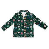 A long-sleeve children's pajama top with a dark green Christmas-themed all-over print featuring Dalmatian dogs, Santa hats, Christmas trees, and holiday text, displayed on a clean white background.