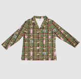 A long-sleeve button-up shirt with a green plaid pattern and an all-over print of golden retriever dogs, pink bows, and small pink signs, shown on a light gray background.