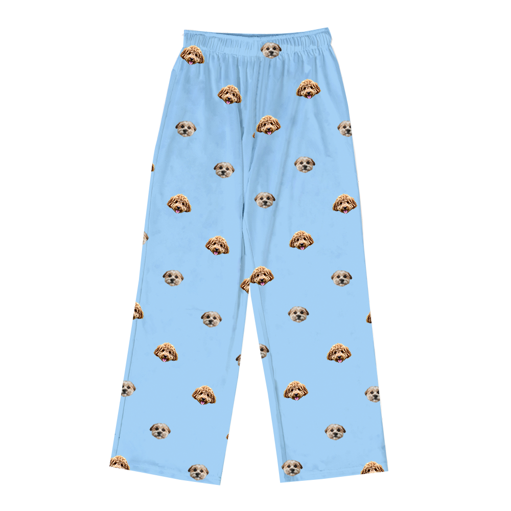 Sky-blue pajama pants featuring a repeating pattern of two dog faces, including a light-colored pup and a curly-haired tan dog.