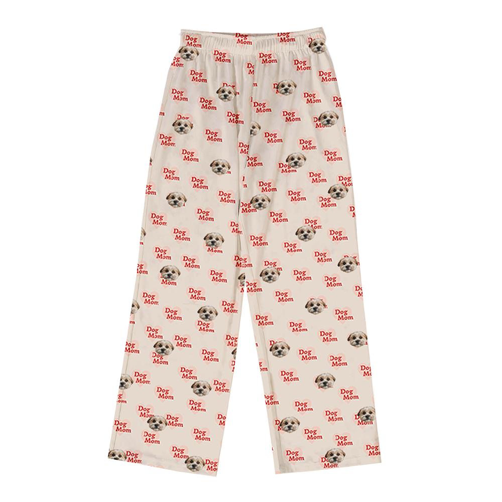 Beige pajama pants covered in a repeating pattern. The pattern features alternating elements: the phrase "Dog Mom" in red text, and smiling headshots of a dog.