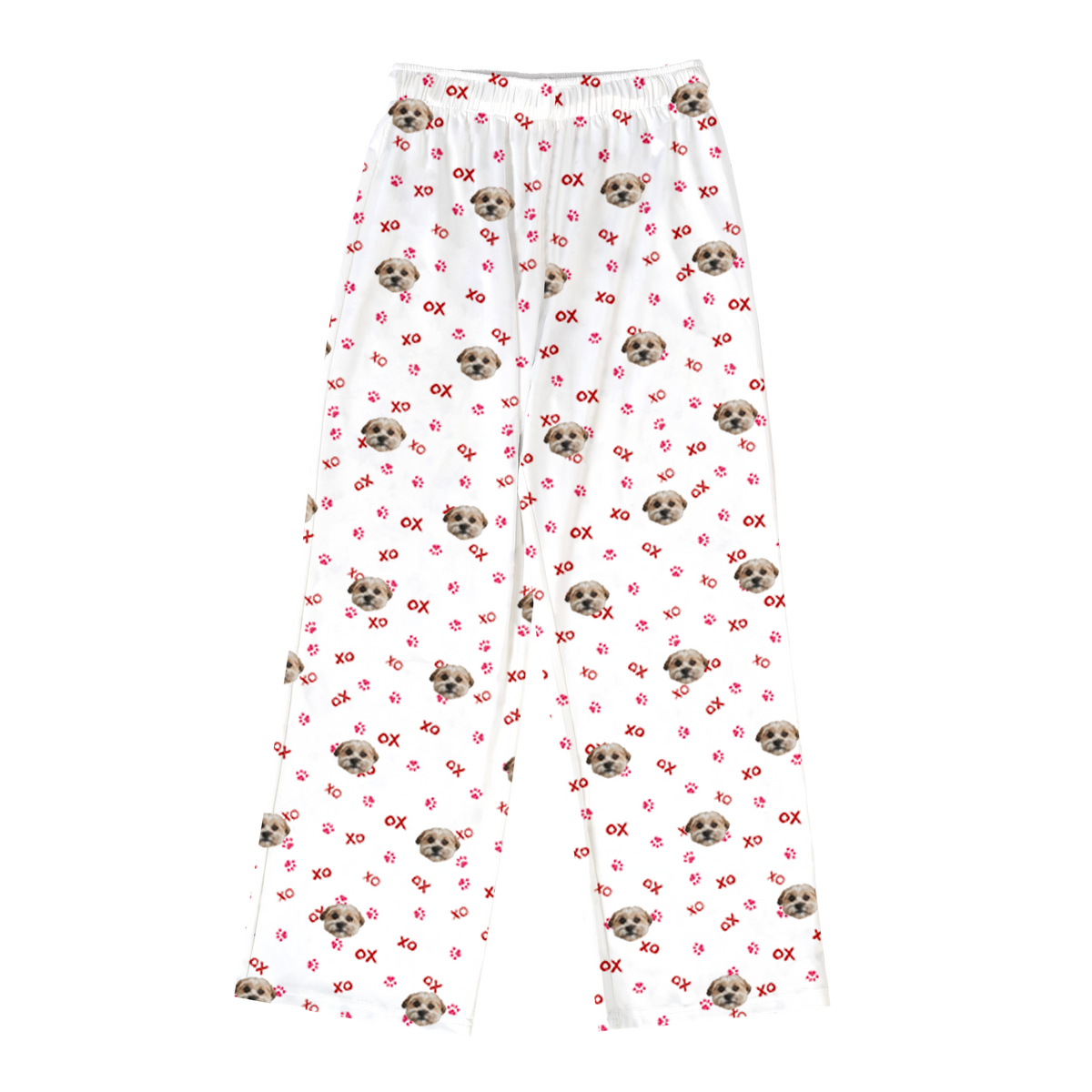 A pair of full-length pajama pants in white with an elastic waistband. The pants feature a pattern of three different dogs' faces, along with scattered red "XO" text and red paw prints.