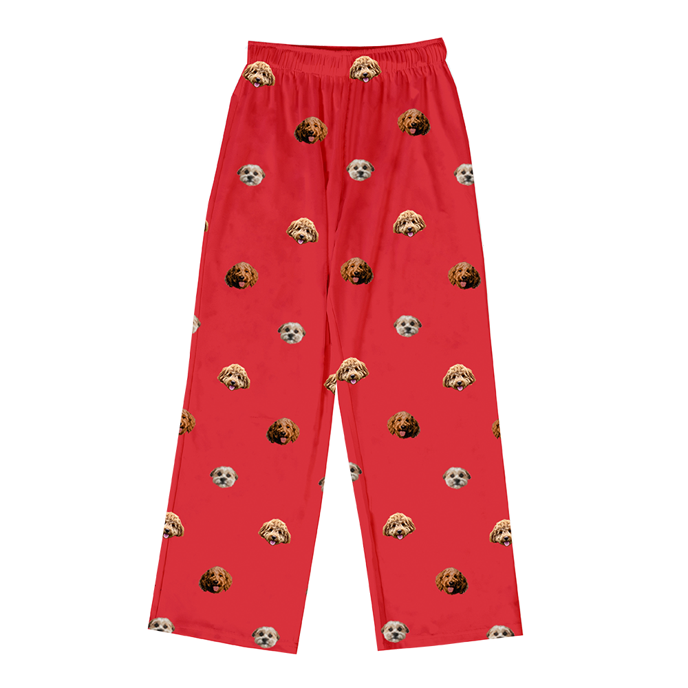Red pajama pants with a custom repeating pattern of the photo heads of three different dogs (two reddish-brown, one light-colored).