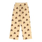 Butter-yellow pajama pants featuring a repeating smiling woman face print across the entire fabric[ButterYellowPajamaPants]