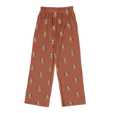 Cocoa-brown pajama pants featuring a repeating print of the same smiling woman’s face across fabric[CocoaPajamaPants]
