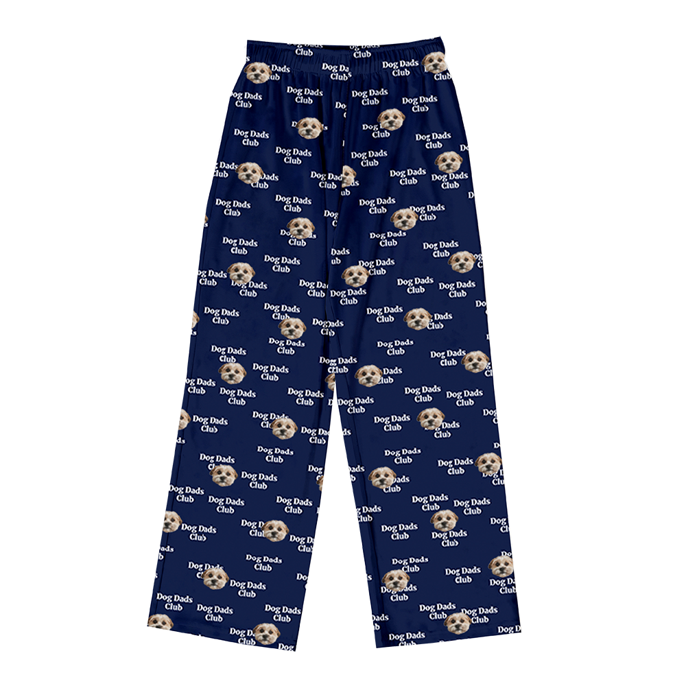 Dark navy blue pajama pants covered in a repeating pattern. The pattern features alternating elements: the phrase "Dog Dads Club" in light text, and smiling headshots of a brown dog. 