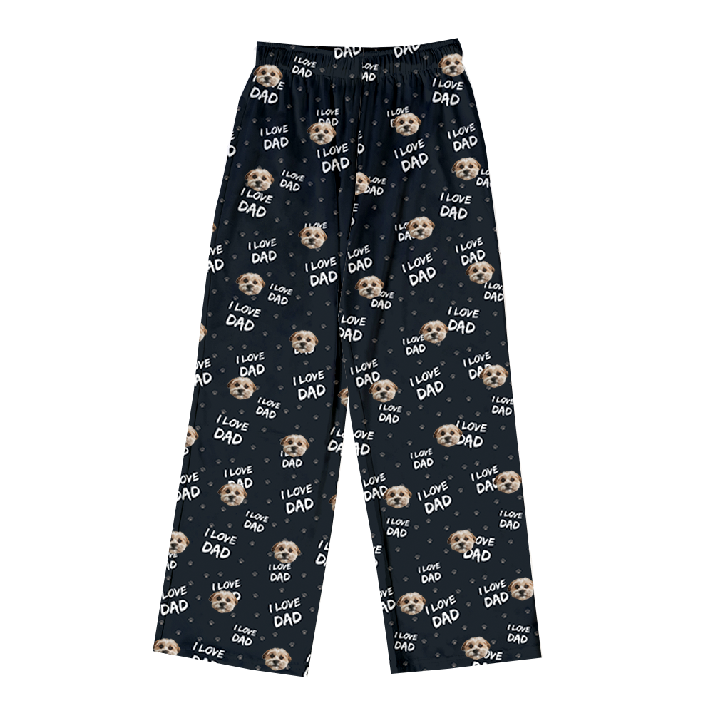 Full-length pajama pants in black with an elastic waistband, featuring a repeating pattern of dog faces, paw prints, and the text "I LOVE DAD."