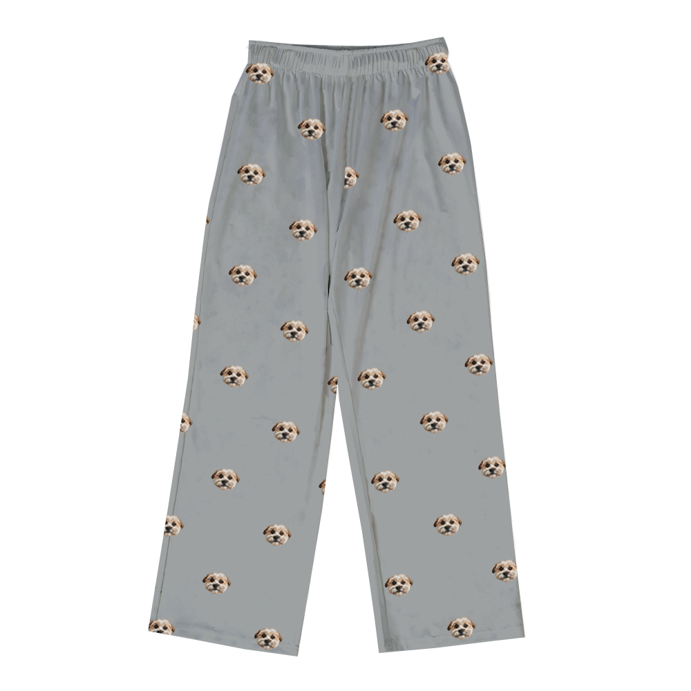 A pair of slate grey, long pajama pants with an elastic waist. The pants feature a repeated, scattered pattern of a single dog face.