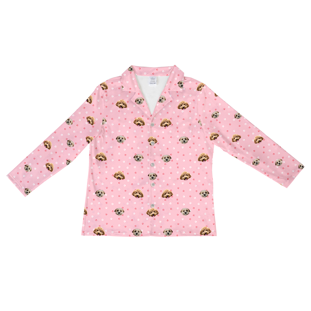 A long-sleeved, button-up pajama top in light pink. The top features a repeating pattern of cartoonish pink and white paw prints, interspersed with realistic photos of two different dogs' heads.