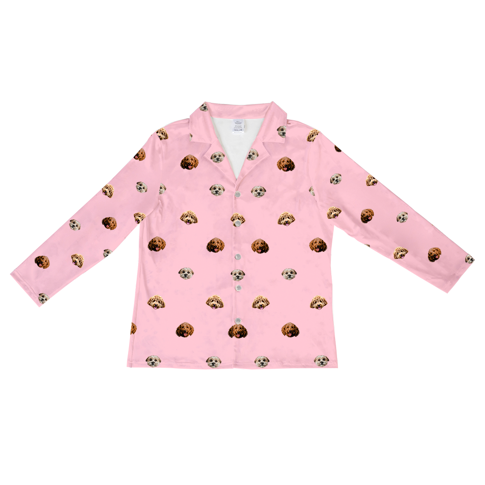 Pink long-sleeved button-up pajama shirt with collar, featuring a scattered pattern of realistic doodle dog faces in brown, tan, and cream colors.