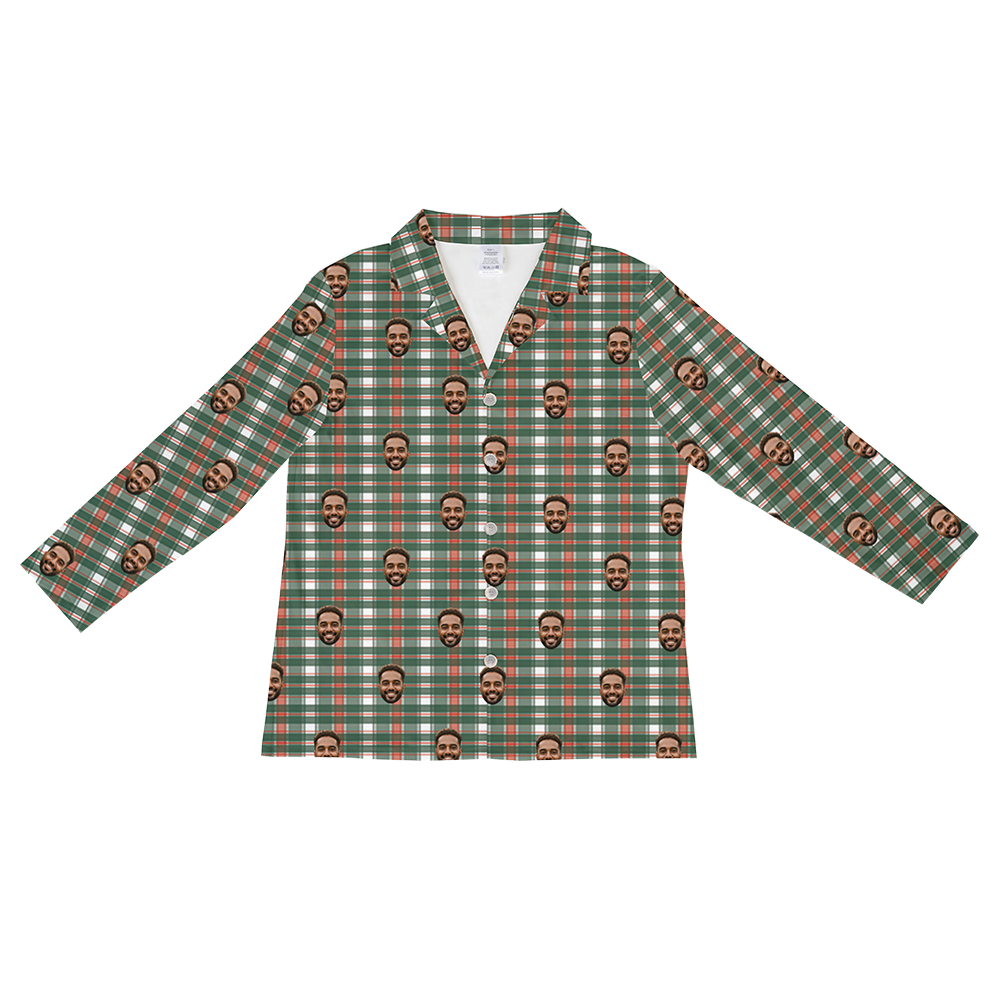 Long-sleeved, button-down pajama shirt in a green, orange-red, and white tartan plaid pattern, overlaid with a repeating pattern of a bearded man's smiling face.