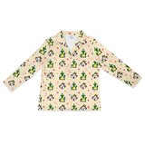 A long-sleeve collared pajama shirt with a cream background and an all-over print of cactus, dog, candy cane, and heart motifs, shown flat against a white background.