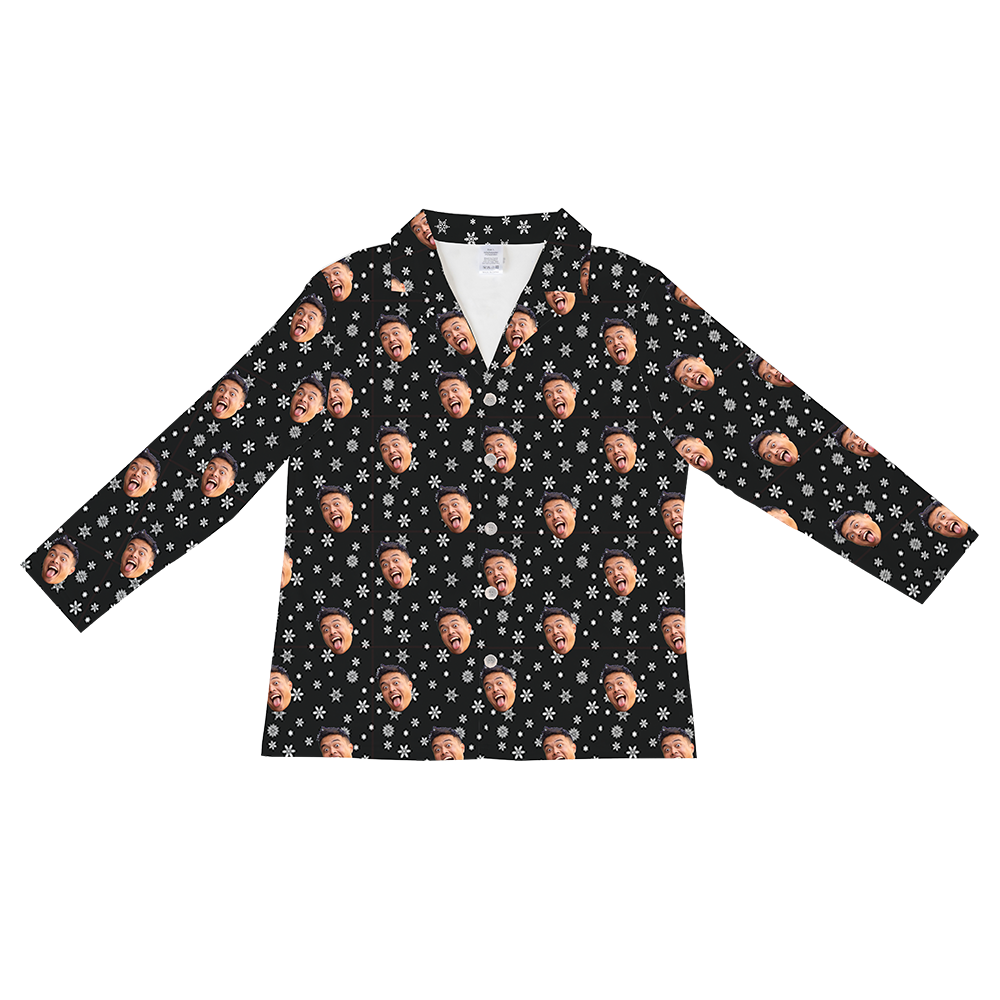 Long-sleeved, button-down pajama shirt in black, patterned with white snowflakes and a repeating pattern of a man's face with a wide, open-mouthed expression.
