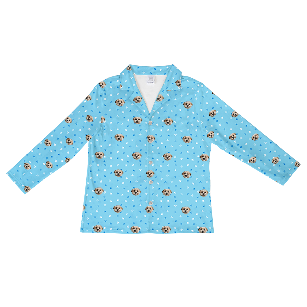 Long-sleeve, button-down pajama top in light blue, featuring a scattered pattern of dog faces, white paw prints, and darker blue paw prints.