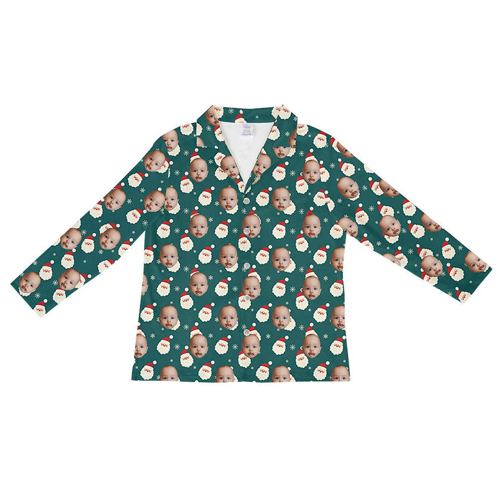 Long-sleeved, button-down pajama shirt in deep teal green, featuring a repeating Christmas pattern of a baby's face wearing a Santa hat, Santa faces with beards, and white snowflakes.