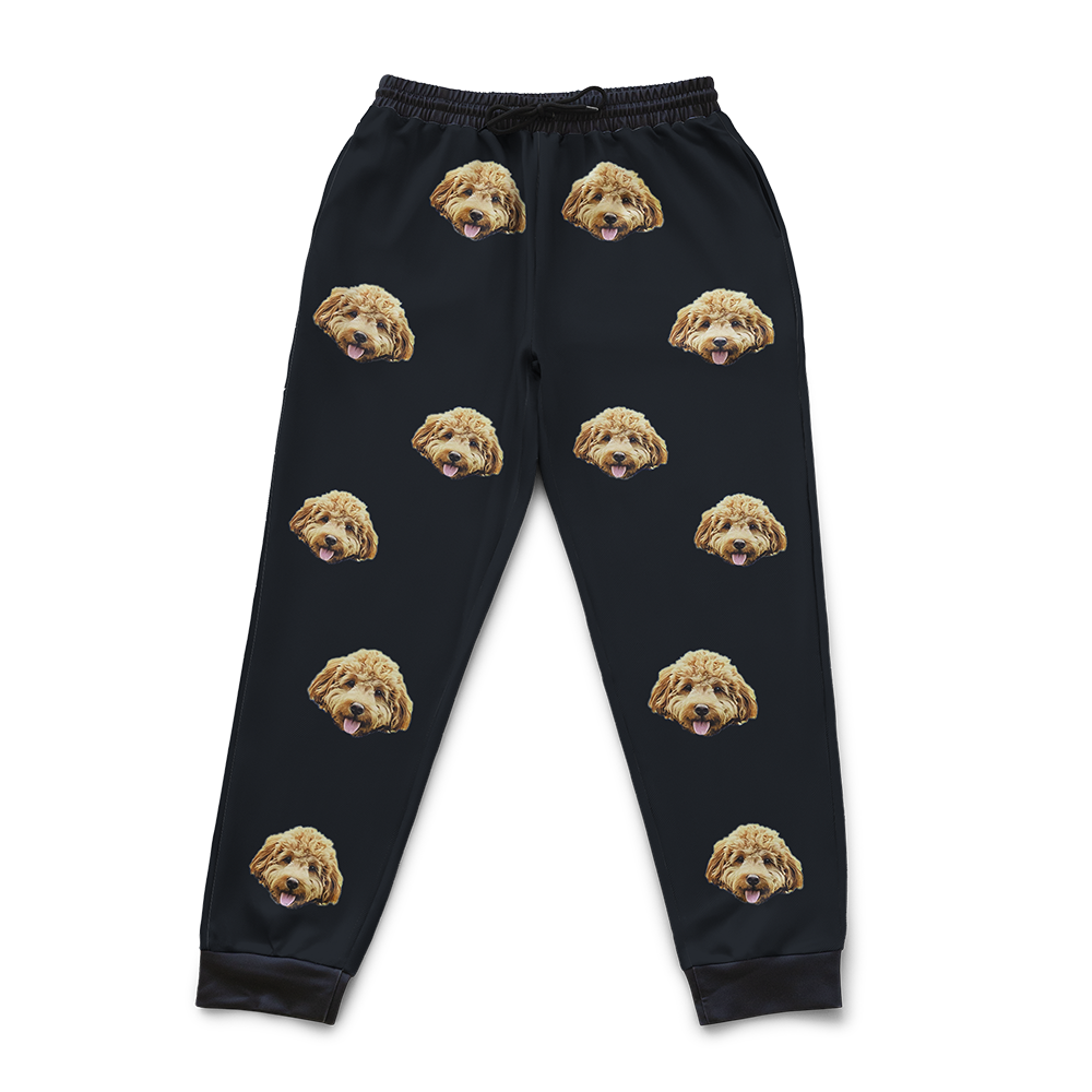 Black pajama pants with dog face pattern on a white background