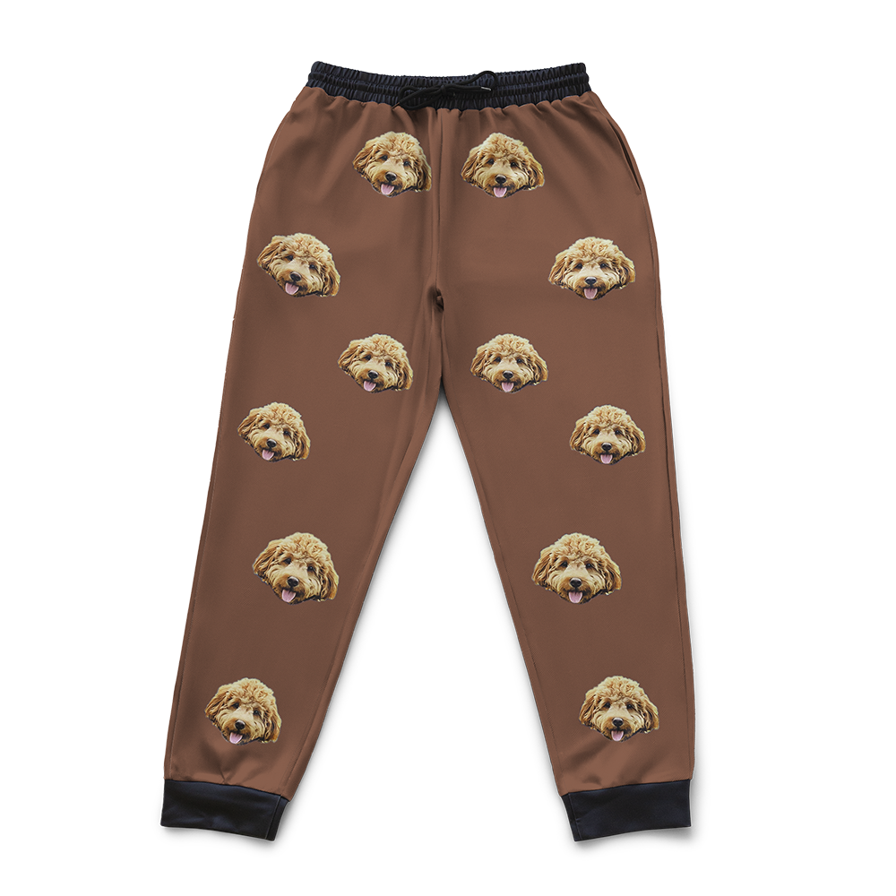 Brown pajama pants with dog face pattern on a white background