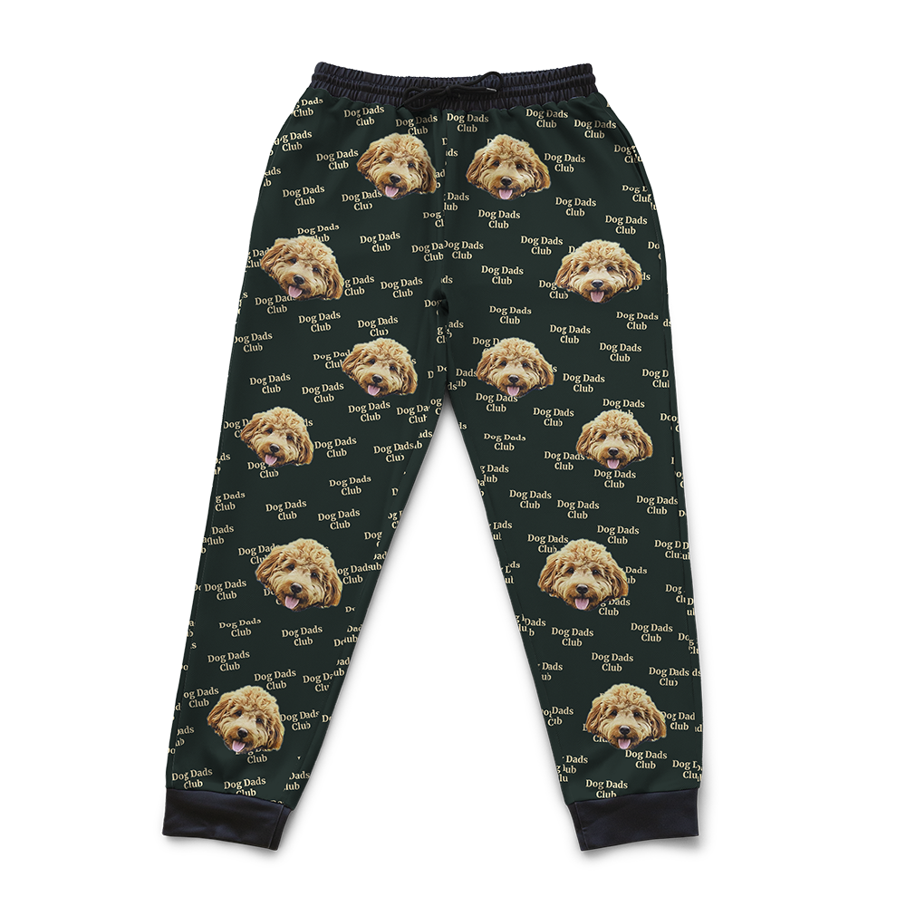 Custom joggers with a green background featuring a repeating pattern of a dog’s face and the text ‘Dog Dads Club’.