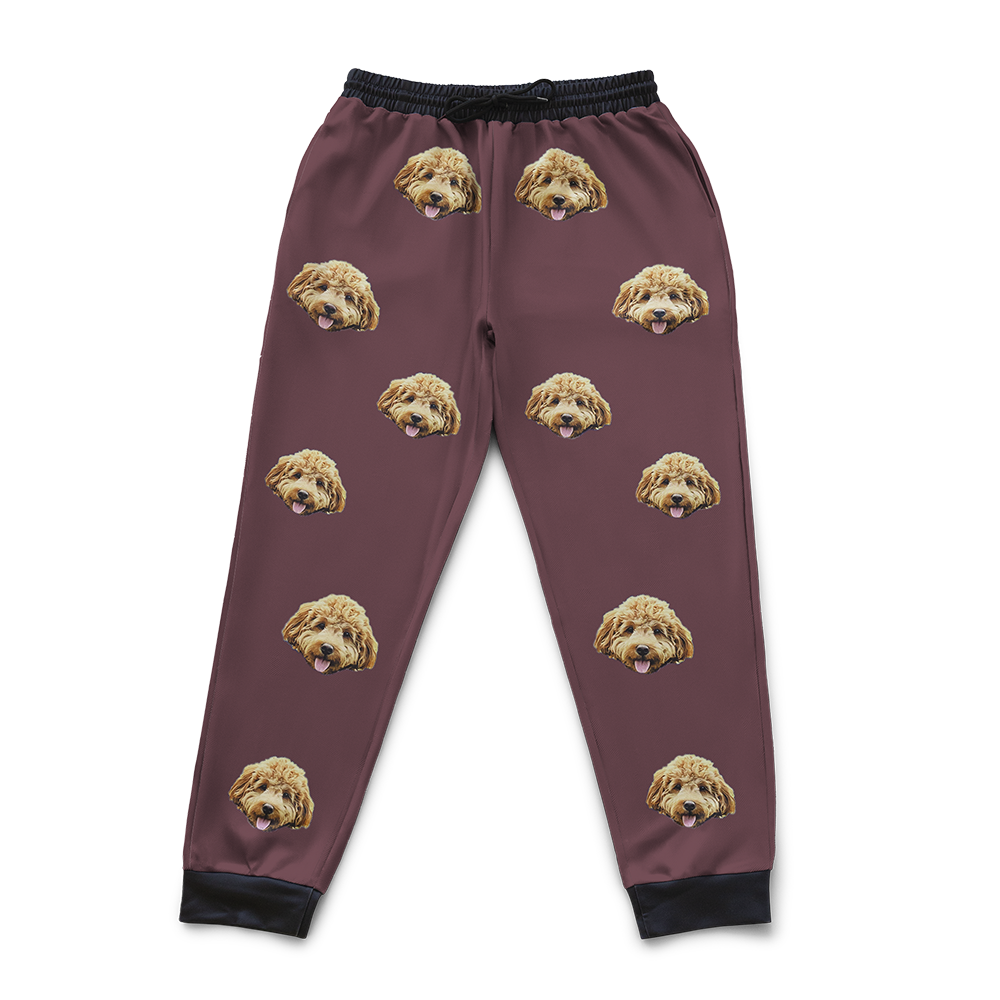 Maroon pajama pants with dog face pattern on a white background