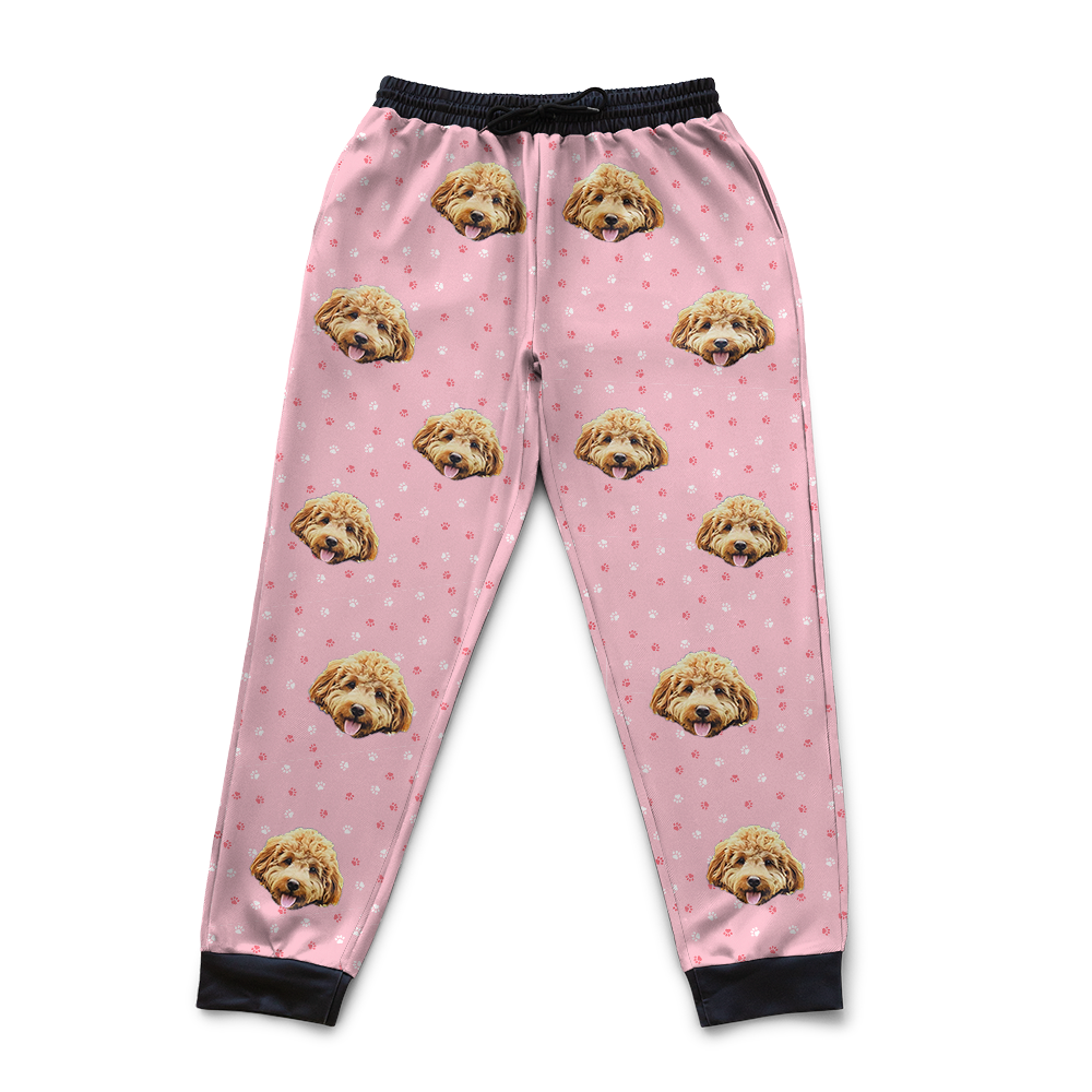 Light pink pajama pants with dog face pattern on a white background