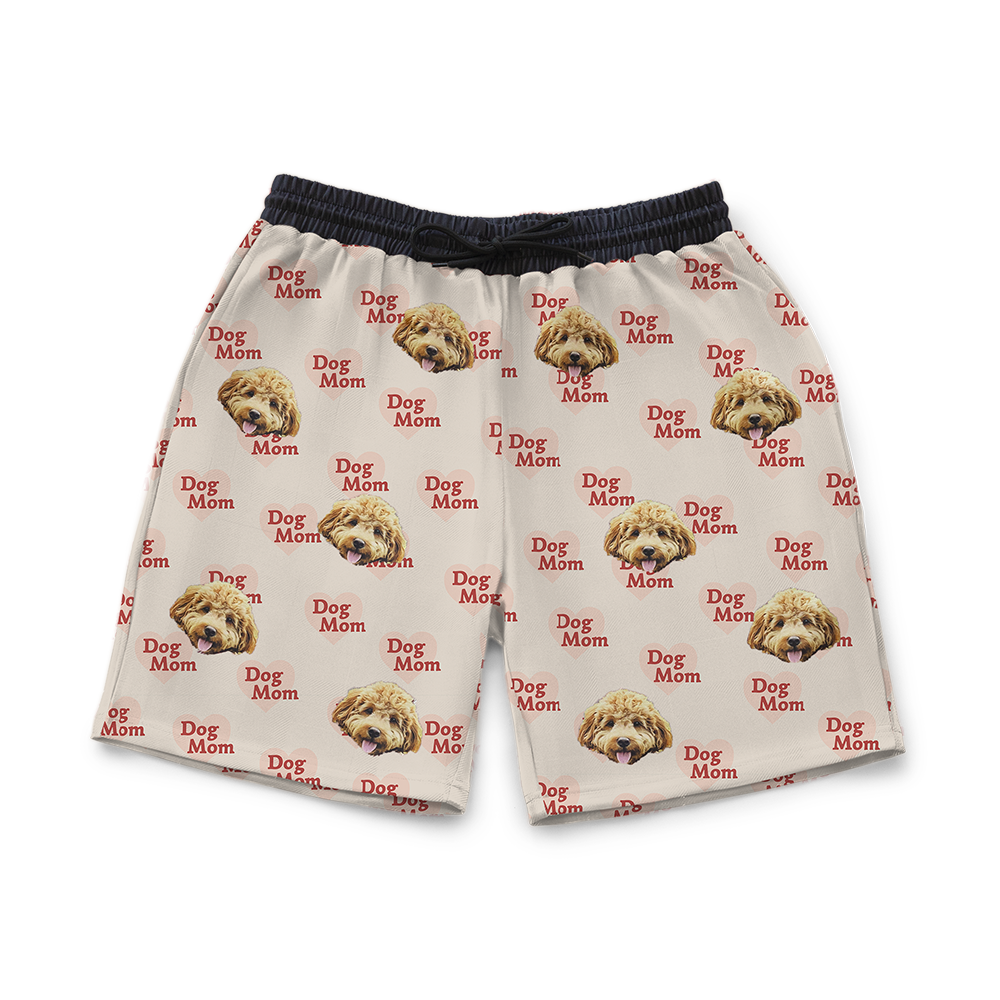 Beige sweat shorts patterned with repeated “Dog Mom” text in red hearts and multiple images of a fluffy tan dog’s face.